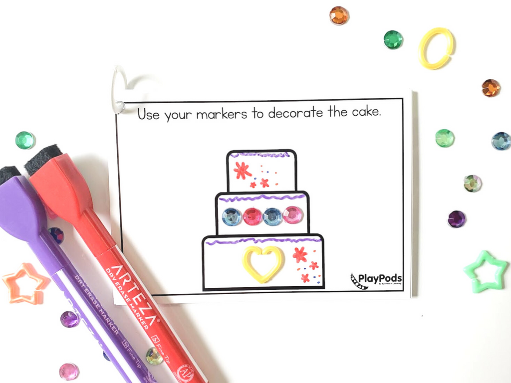 Drawing of a cake on an activity card with markers and gems to decorate it