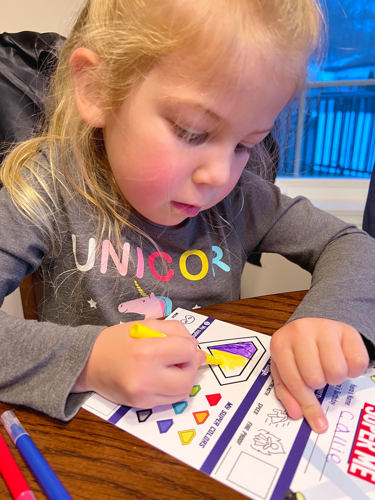 Little girl coloring an activity card
