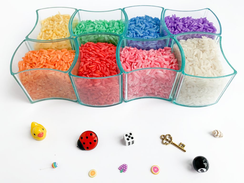 Clear containers of colorful rice and various toy charms