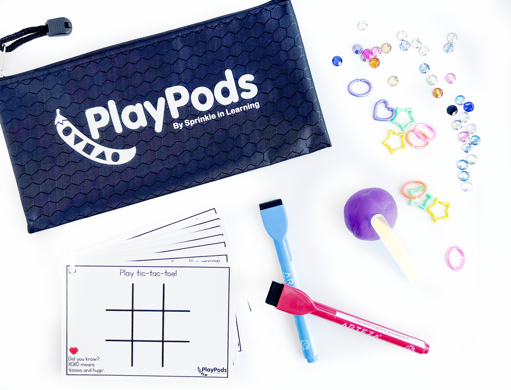 Black PlayPod pouch with dry eraser markers, activity cards, activity dough, shiny gems, and pastel links