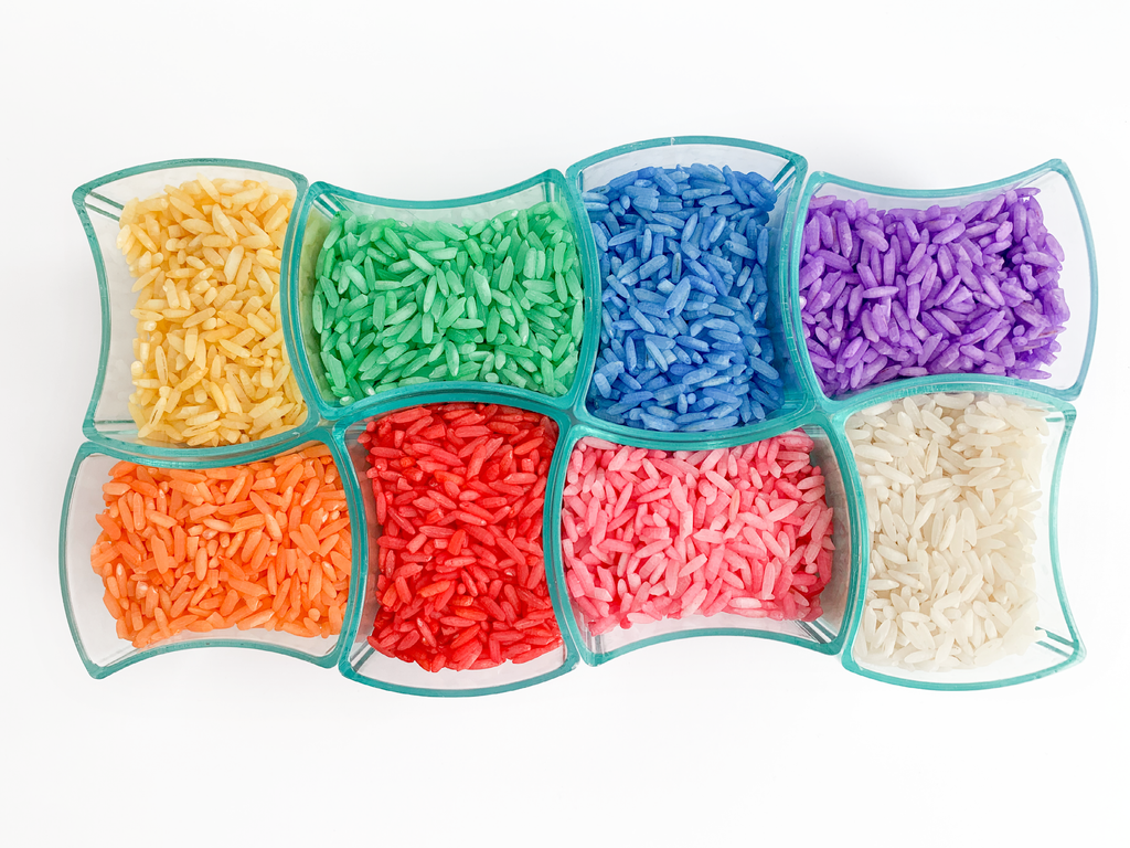 Colorful rice separated by color in clear containers