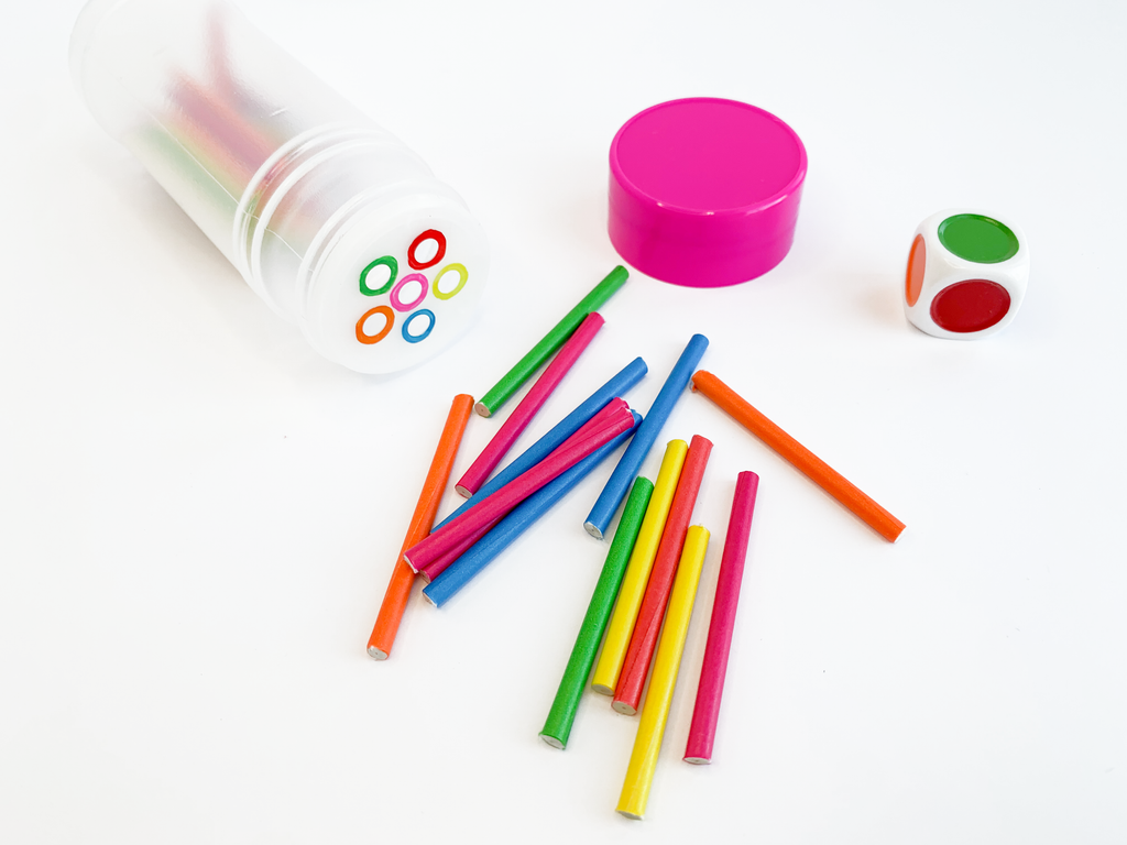 Colorful sticks and die on table with shaker 