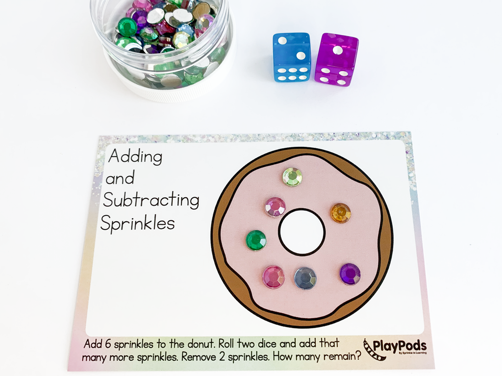 Donut activity card, colorful dice, and a jar of sparkly colorful gems