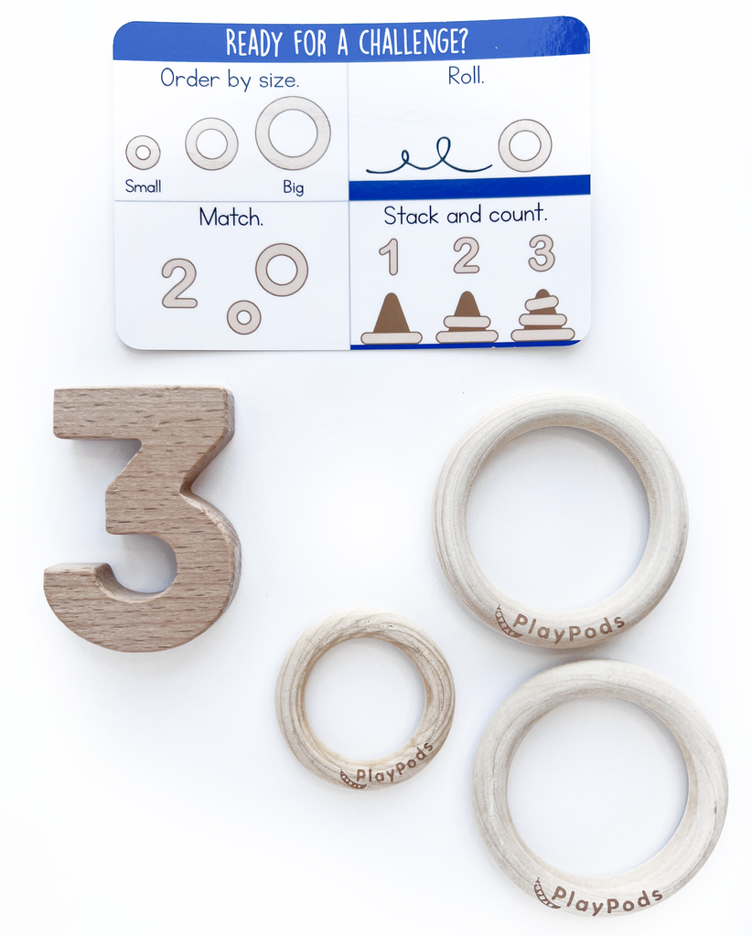 Play instruction card with a wooden number three and three wooden rings